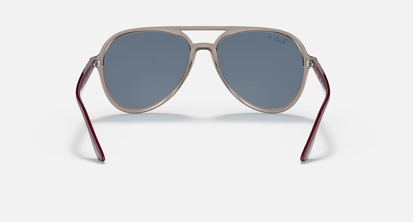 A pair of aviator sunglasses with a metallic silver frame, blue-gray lenses, and dark red temples, shown from the back on a light gray background.